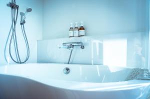 KarimataBlack Diamond 宮古島的浴室设有带淋浴的白色浴缸。