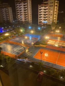 通苏帕Departamento 4 habitaciones 12 personas vista al mar 8vo piso Playa Almendro的夜间在城市里带灯光的网球场