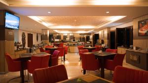 梭罗Lorin Dwangsa Solo Hotel的一间带桌椅的餐厅和一间厨房