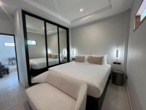 苏梅岛Moorea Boutique Resort Samui的一间卧室配有一张床、一张沙发和一面镜子