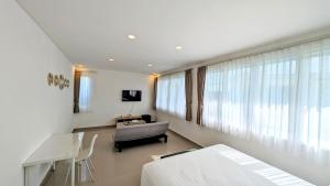 孟威Ohana Retreat Bali的一间卧室配有一张床、一张桌子和一张沙发