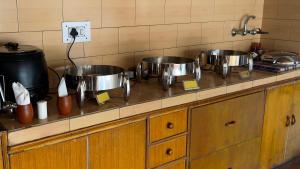 列城Rock Castle Residency的厨房在柜台上配有三锅锅碗瓢盆