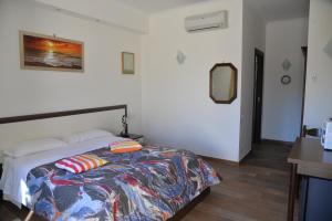 Le FerriereLa Tenuta del Passero的一间卧室配有一张带五颜六色棉被的床