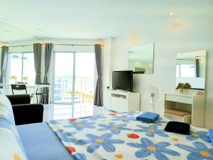 乔木提恩海滩Sea View Beachfront Condos Pattaya Jomtien Beach的一间卧室配有一张带花卉图案的大床