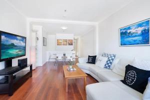 悉尼Perfect Pyrmont penthouse with Sydney Tower View的客厅配有白色的沙发和桌子