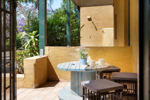 悉尼Suburban Two-bed Apartment with Parking and Patio的一个带桌子和两张凳子的庭院