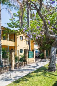 悉尼Suburban Two-bed Apartment with Parking and Patio的一座建筑物前有紫色花的树
