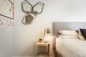 悉尼Suburban Two-bed Apartment with Parking and Patio的卧室配有一张床,墙上有两面镜子