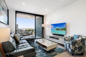 布里斯班Convenient 2-Bed Apartment with Panoramic Views的带沙发和平面电视的客厅
