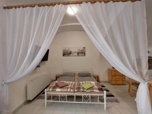 莱沃恰apartmány LEVOČA的一间卧室配有白色窗帘的床