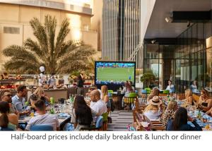 迪拜Crowne Plaza Dubai Marina, an IHG Hotel的一群坐在餐厅桌子上的人