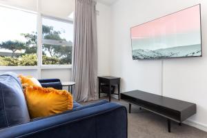 悉尼Comfy Balcony Studio near Parks, Shopping & Dining的客厅设有蓝色的沙发和窗户。