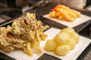 草津亀之井酒店草津YUBATAKE(Kamenoi Hotel Kusatsu Yubatake)的两盘带肉和土豆的白菜