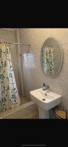 AdiebabaBAFFOUR APARTMENTS的浴室配有盥洗盆和带镜子的淋浴
