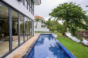 岘港Ocean Sunny Villas Da Nang的房屋后院的无边游泳池