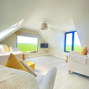 特拉利Luxury holiday rental with sea views on the Wild Atlantic Way的阁楼客厅配有白色家具和大窗户