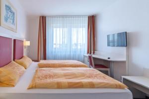 诺登诺登公寓式酒店的酒店客房配有两张床和一张书桌