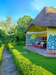 卡巴莱Paradise Eco-Hub的茅草屋顶和花园