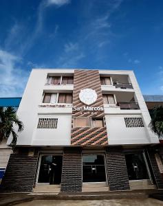 巴兰基亚Hotel San Marcos Barranquilla的一座高大的白色建筑,上面有标志