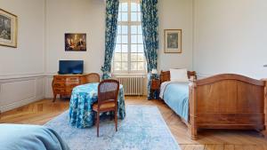 拉弗雷切La Templerie - Chambres d'hôtes的一间卧室配有一张床、一张桌子和一个窗户。