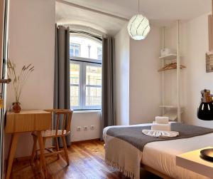 里斯本262 Baixa Guesthouse的一间卧室配有一张床、一张书桌和一个窗户。