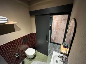 伊斯坦布尔BKM Hostel的一间带卫生间、水槽和镜子的浴室
