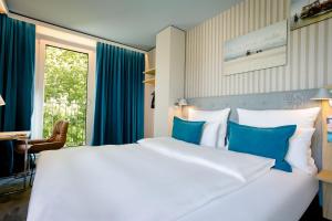 罗斯托克罗斯托克汽车旅馆的卧室配有带蓝色枕头的大型白色床