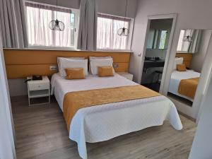 法蒂玛哈利路亚酒店的一间卧室设有一张大床和两个窗户。