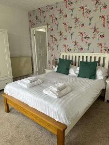 GulvalThe Coldstreamer的卧室配有带绿色枕头的大型白色床