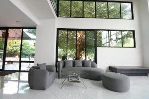 奈扬海滩S4 Nai Yang Beach - SHA EXTRA PLUS的带沙发和玻璃桌的客厅
