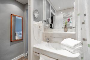 腓特烈港Select Hotel Friedrichshafen的白色的浴室设有水槽和镜子