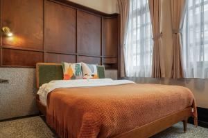 基隆安樓文旅Enzo House的一间卧室配有一张带大型木制床头板的床
