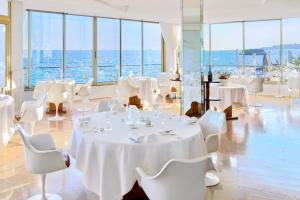 马赛贝迪尼斯贝斯达酒店的一间设有白色桌椅的海洋餐厅