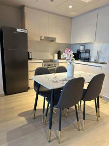 阿布扎比F1 Circuit View 1 Bd Apartment的厨房配有桌椅和冰箱。