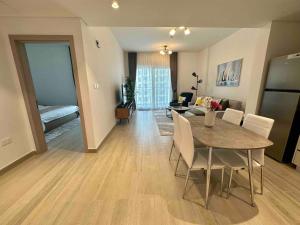 阿布扎比Spacious 1br With Seaworld View Yas Island 308的用餐室以及带桌椅的起居室。