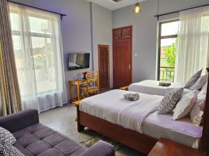 NgateuMedan Hotel的一间卧室配有两张床、一张沙发和一台电视