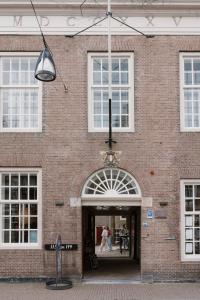 多德雷赫特Stadsklooster Dordt Hotel&Hostel的一座砖砌建筑,两个人在门口走