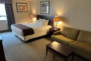 伦敦伦敦华美达酒店的酒店客房,配有床和沙发