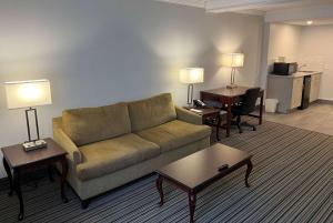 伦敦伦敦华美达酒店的客厅配有沙发、桌子和书桌