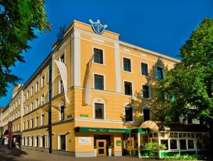 格拉茨Parkhotel Graz - Traditional Luxury的黄色的建筑,上面有钟