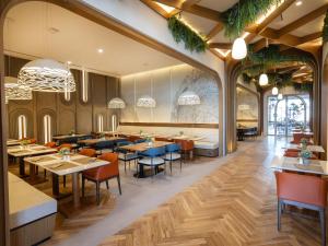 迪拜The First Collection Waterfront的餐厅铺有木地板,配有桌椅