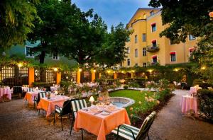 格拉茨Parkhotel Graz - Traditional Luxury的一座带桌椅的花园以及一座建筑