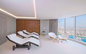 迪拜Andaz by Hyatt – Palm Jumeirah的一间医院的等候室,配有白色的椅子和窗户