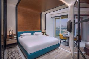 迪拜Andaz by Hyatt – Palm Jumeirah的一间卧室配有一张床、一张书桌和一台电视