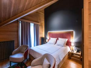 科拉欣Swissôtel Resort Kolasin的一间卧室配有一张大床和两把椅子