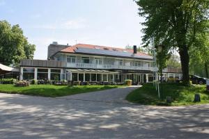 阿珀尔多伦Hotel Oranjeoord的前面有一棵树的白色大建筑