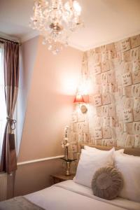巴黎La Maison Gobert Paris Hotel Particulier的一间卧室配有吊灯和一张带枕头的床