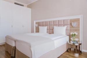 索非亚Impresamente Art Hotel的白色卧室配有一张大床和一张桌子