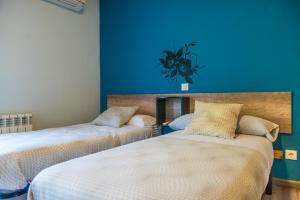坎德莱达Hostal La Pastora的蓝色墙壁客房的两张床