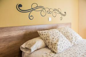 坎德莱达Hostal La Pastora的卧室配有一张挂有墙上标志的床